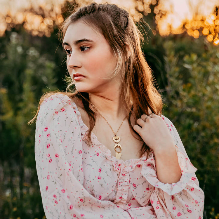 moon phases // half moon, waxing, waning crescent moons, new moon and long triangle pendant necklace worn on model - Peacock & Lime