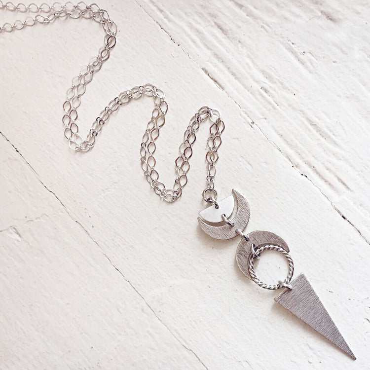 moon phases // half moon, waxing, waning crescent moons, new moon and long triangle pendant necklace by Peacock & Lime