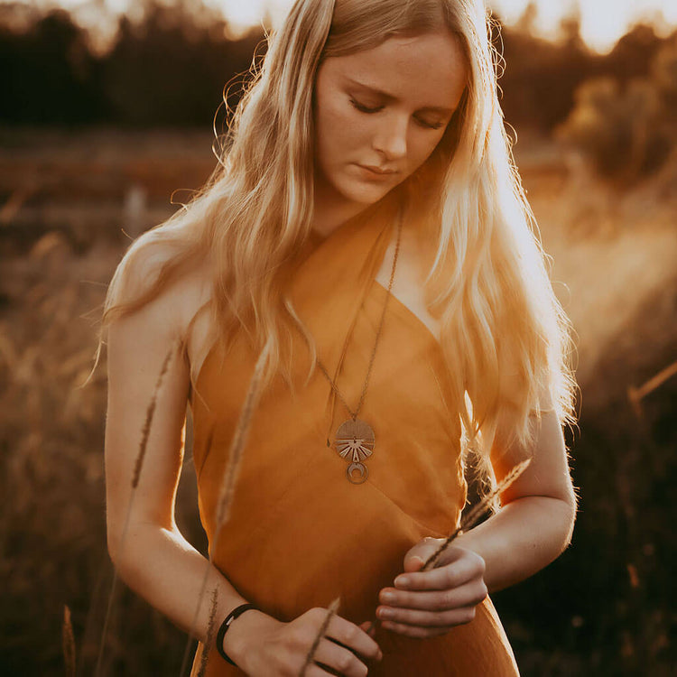 orbis // patina aged darkened sun, moon, sphere & crescent moon necklace worn on model - by Peacock & Lime